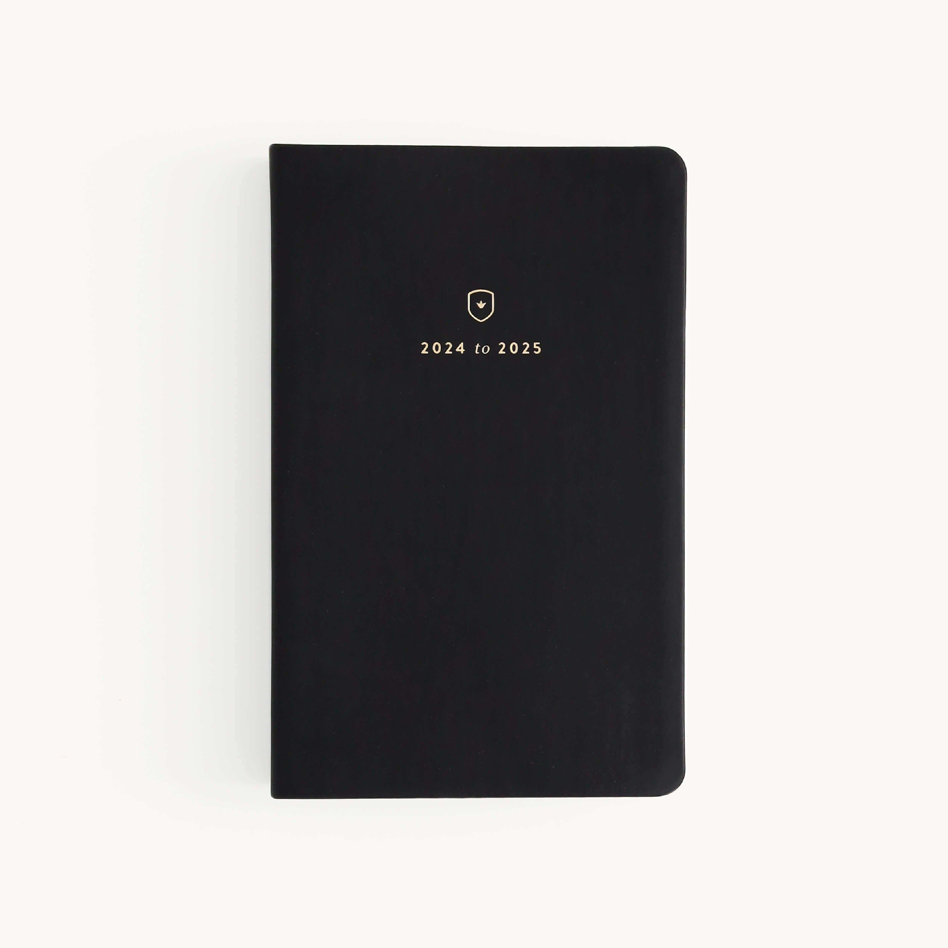 The Simplified 2024-2025 Daily Dapperdesk Planner - Black Tie features a luxurious leatherette cover with elegant gold text, set against a plain white background.