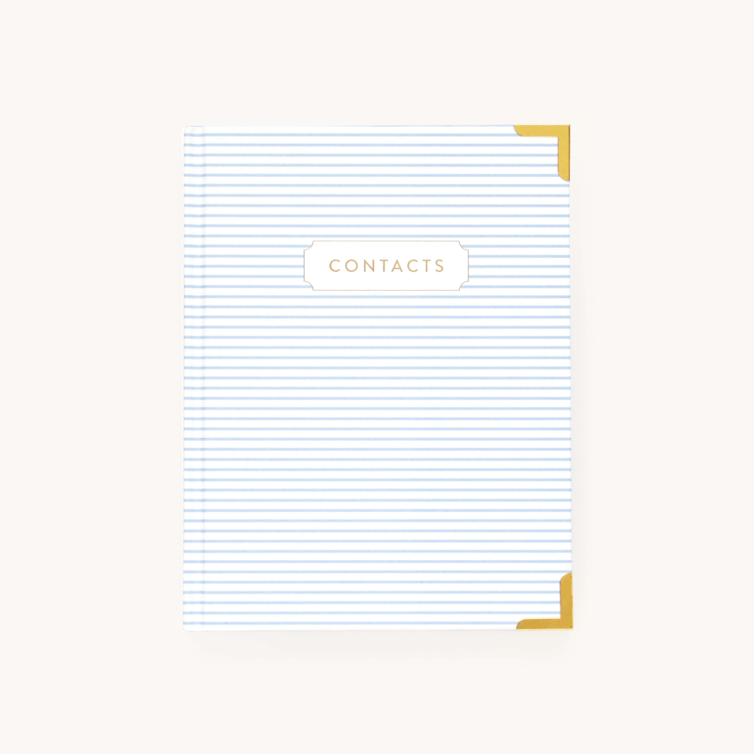 The Simplified Address Book features a white and blue striped cover with gold corners. The word CONTACTS is elegantly displayed in gold on a central white plaque, ideal for organizing holiday mail or essential contacts, set against a light beige background.