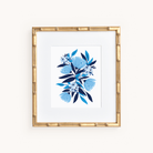 The Art Print - Blue Blooms by Simplified is a framed artwork featuring blue and white floral designs on a white background. It showcases an elegant gold frame with a bamboo-like texture, perfect for blending into any art collection.