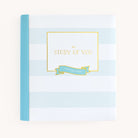 The Simplified Baby Book - Mint is a hardcover with light blue and white stripes, featuring a blue spine and The Story of You on the cover, plus a small blue ribbon. Inside are guided spaces for capturing every special moment.