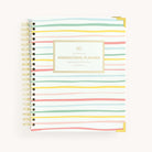 Simplified Homeschool Planner by Emily Ley featuring a painted stripe cover, gold protective corners, and a gold wire-o binding.