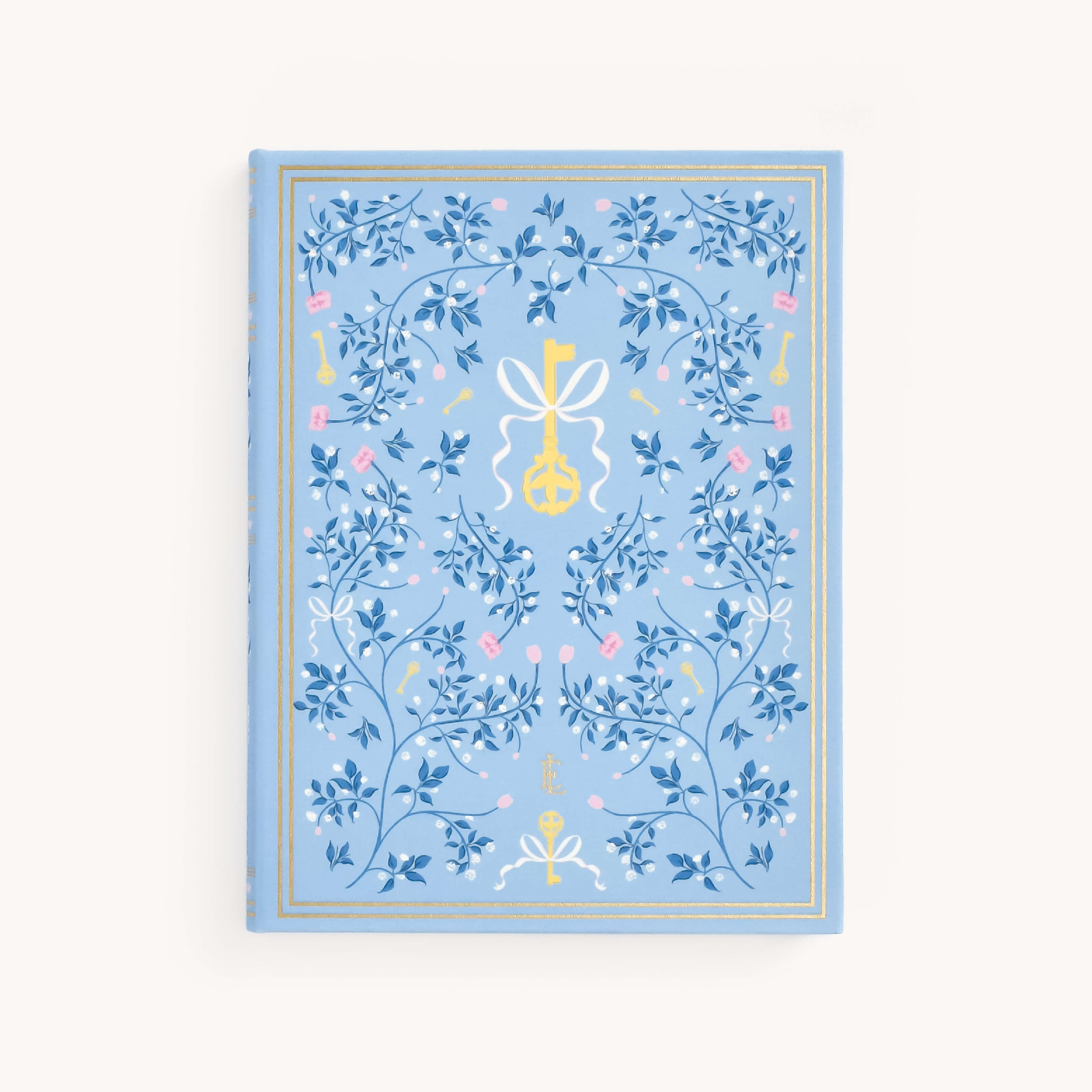 The Linen Journal - Carolina by Simplified features a light blue cover adorned with detailed floral and key motifs in blue and gold. A ribbon-tied key design highlights the center, surrounded by an elegant gold border, creating a masterpiece for reflection.