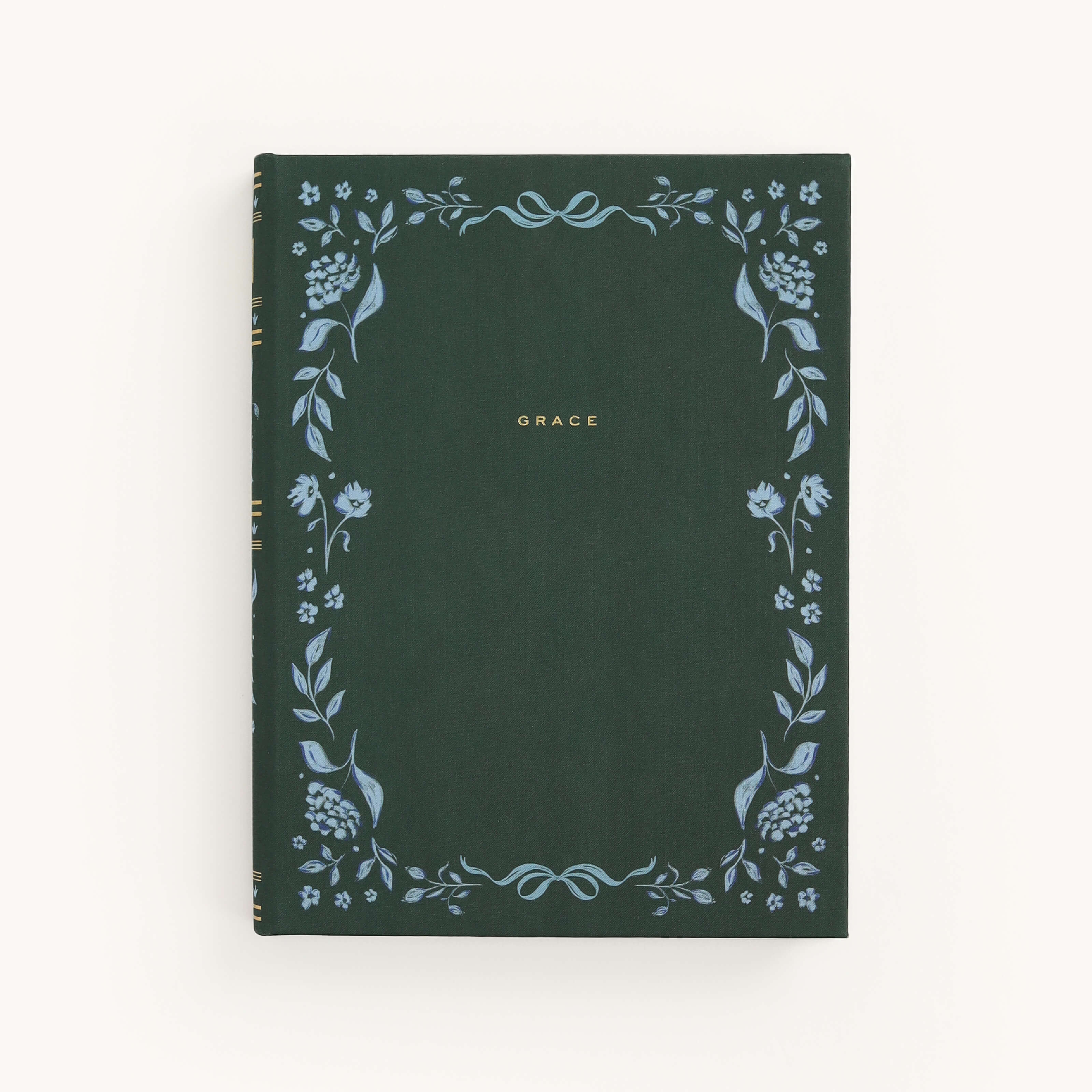 The Simplified Linen Journal - Grace features a dark green hardcover with GRACE embossed in gold at the center. It boasts intricate, hand-painted light blue floral designs along the edges, creating a delicate border of leaves and flowers.