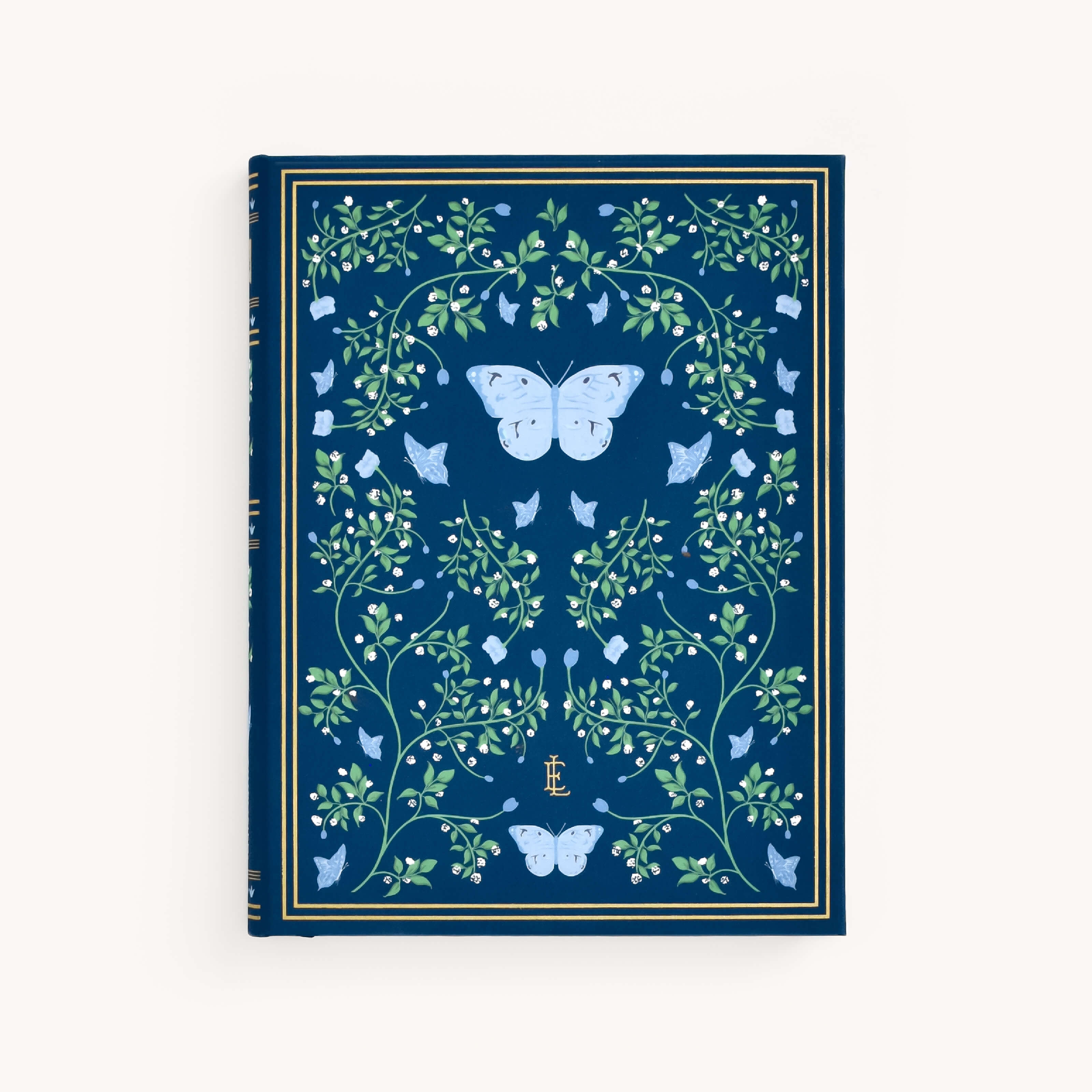 The Linen Journal - Navy by Simplified showcases a detailed design of green vines and leaves, centered with two large blue butterflies. Smaller butterflies are scattered throughout the cover for a creative and reflective touch, all elegantly encased within a gold border.