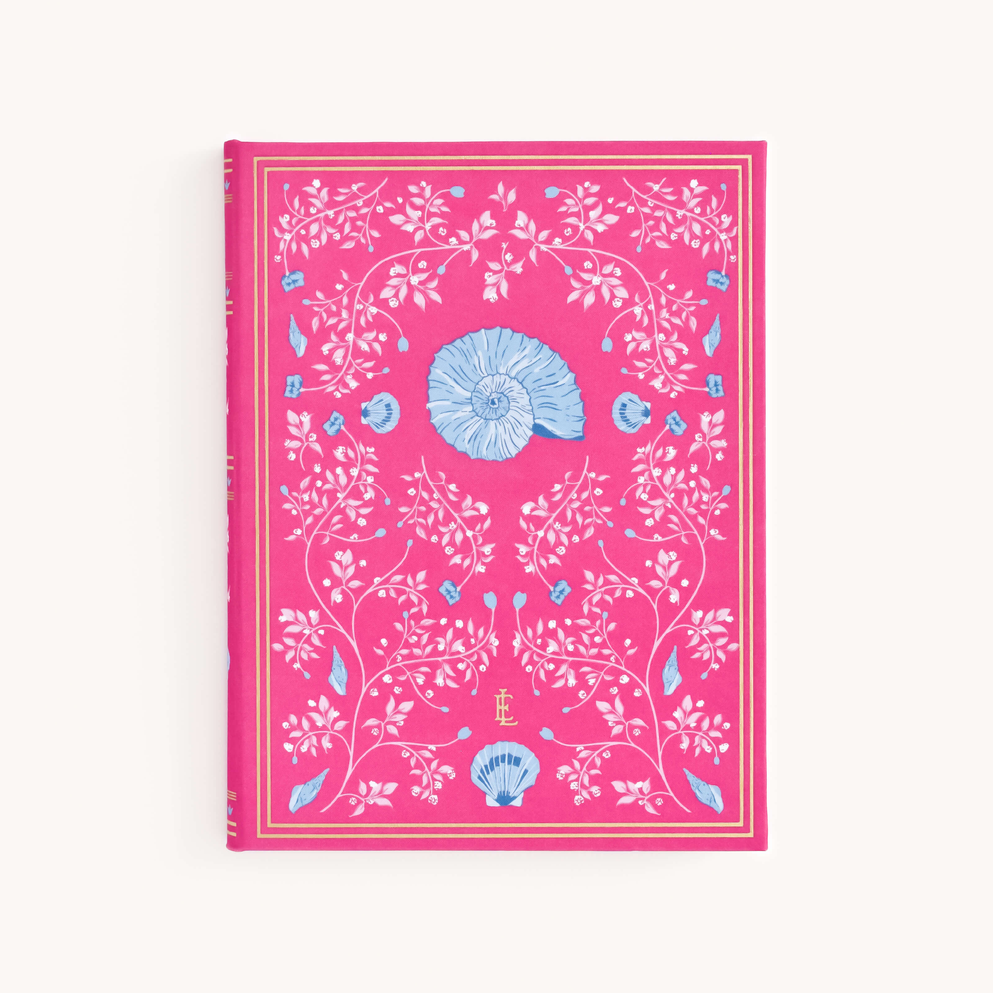 The Simplified Linen Journal - Raspberry showcases a bright pink cover with intricate blue shell illustrations, ornate white floral patterns, and gold decorative borders. The initials EL are centered at the bottom, all set against a plain white background to inspire creativity.