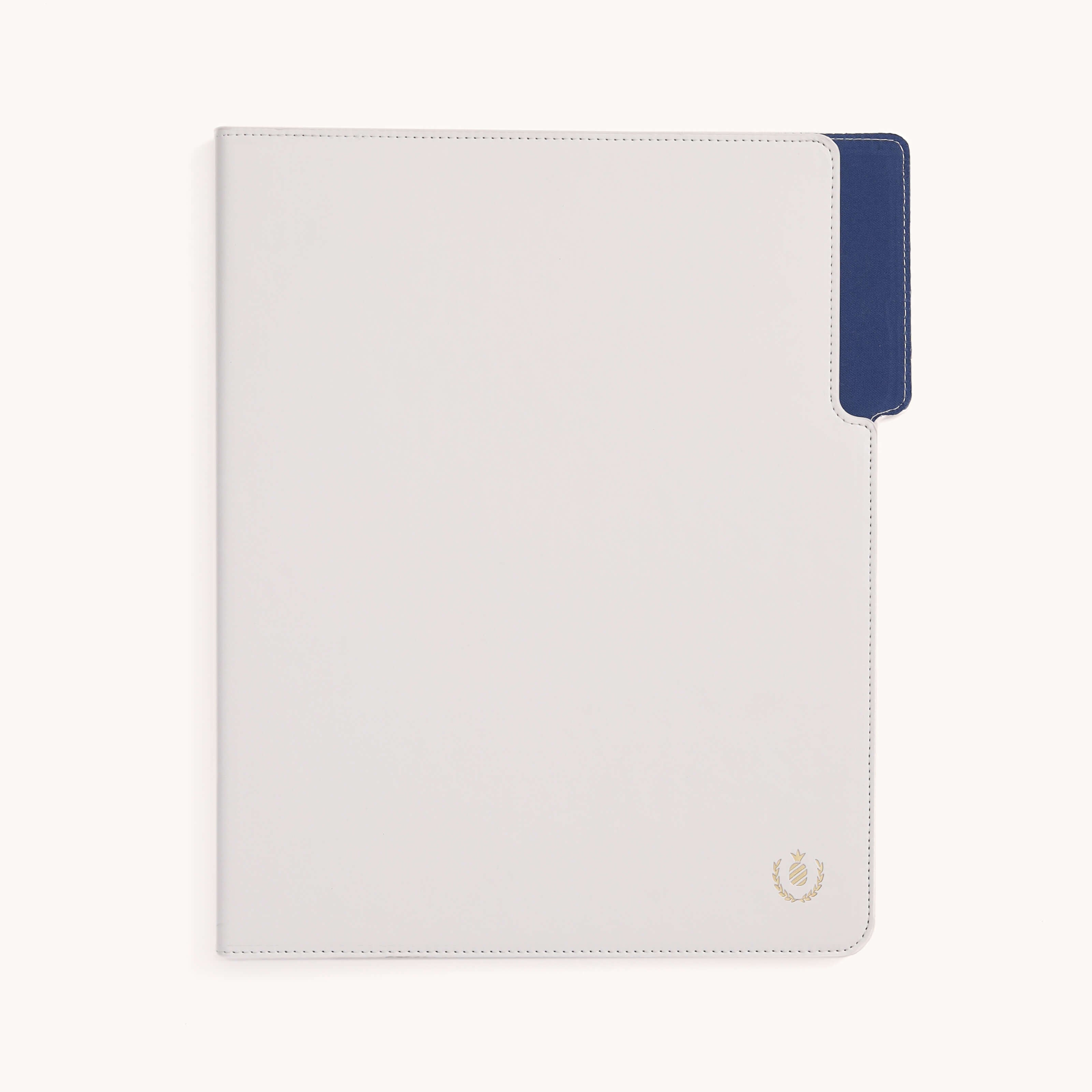 The Simplified Leatherette File Folder - Ivory is white and rectangular with a navy blue tab on the right side. It features a small gold pineapple emblem with a laurel wreath in the bottom right corner. Visible stitching enhances both style and durability, perfect for office organization.