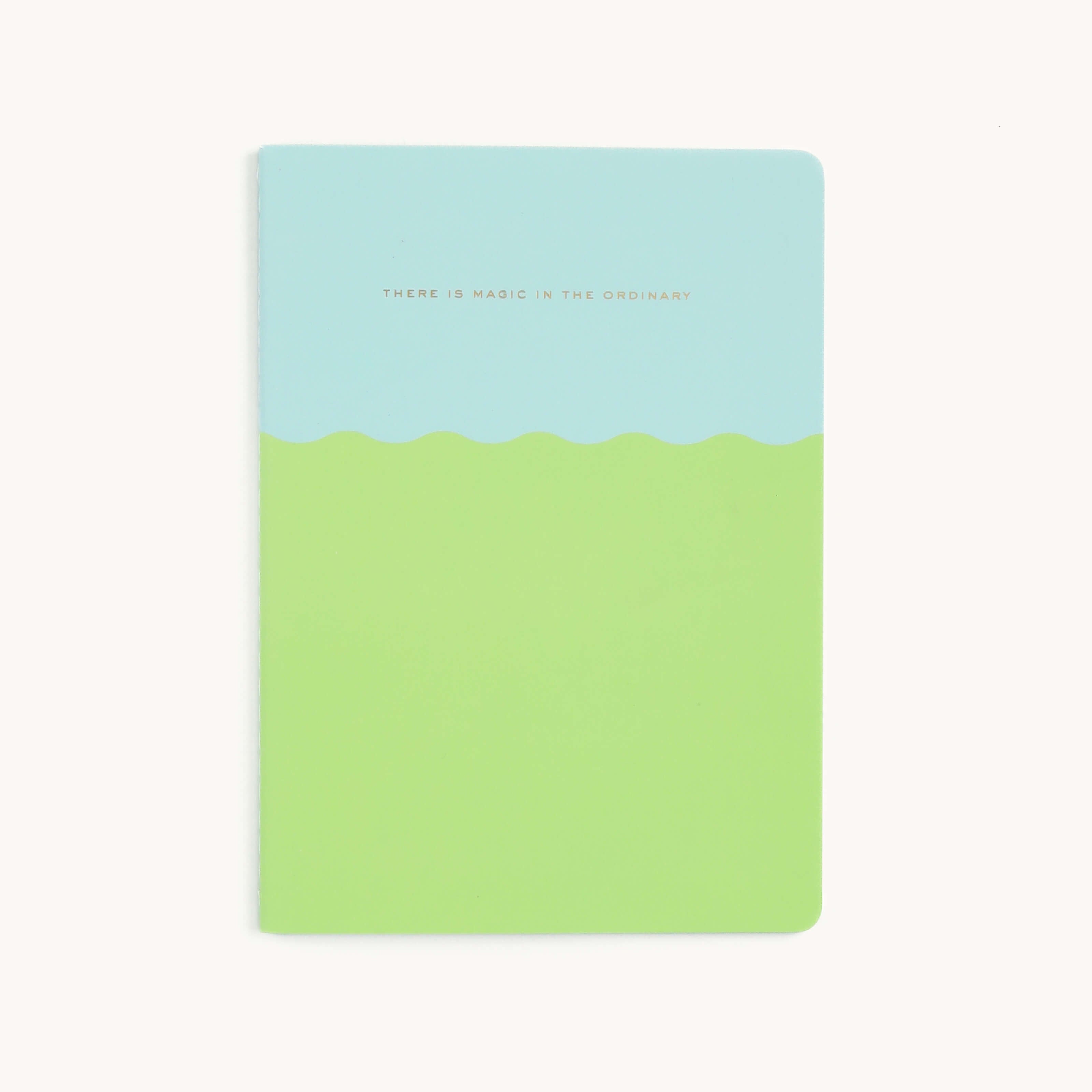 Simplifieds Mid-Size Notebook - Magic In The Ordinary features a stylish pastel green and light blue wavy cover with durable saddle-stitched binding and elegant gold text, There is magic in the ordinary.