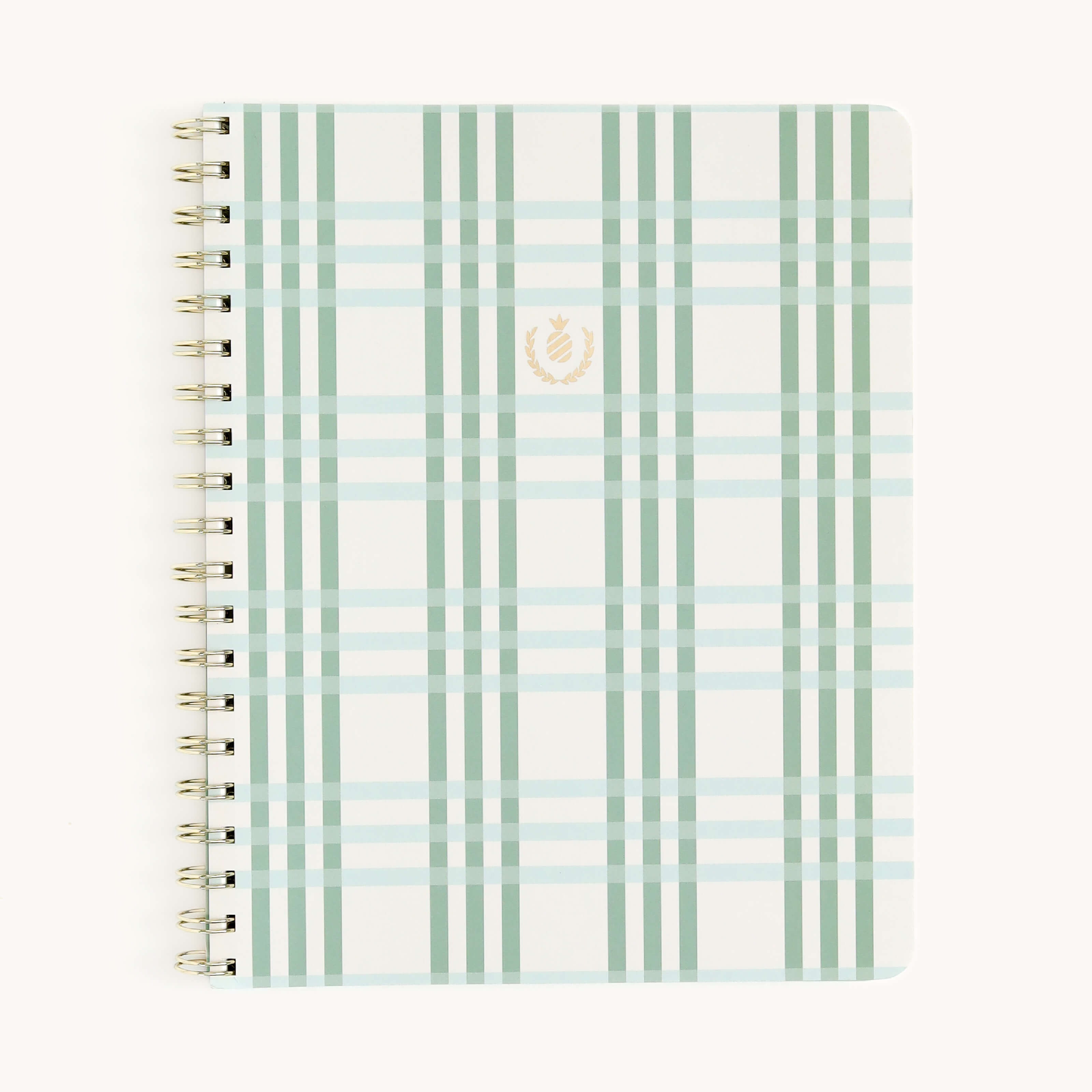 The Notebook - Pistachio Plaid by Simplified features a spiral-bound design with gold wire-o binding and a light green and cream plaid cover. It has a small, gold emblem on the center of its soft-touch cover on a plain white backdrop.