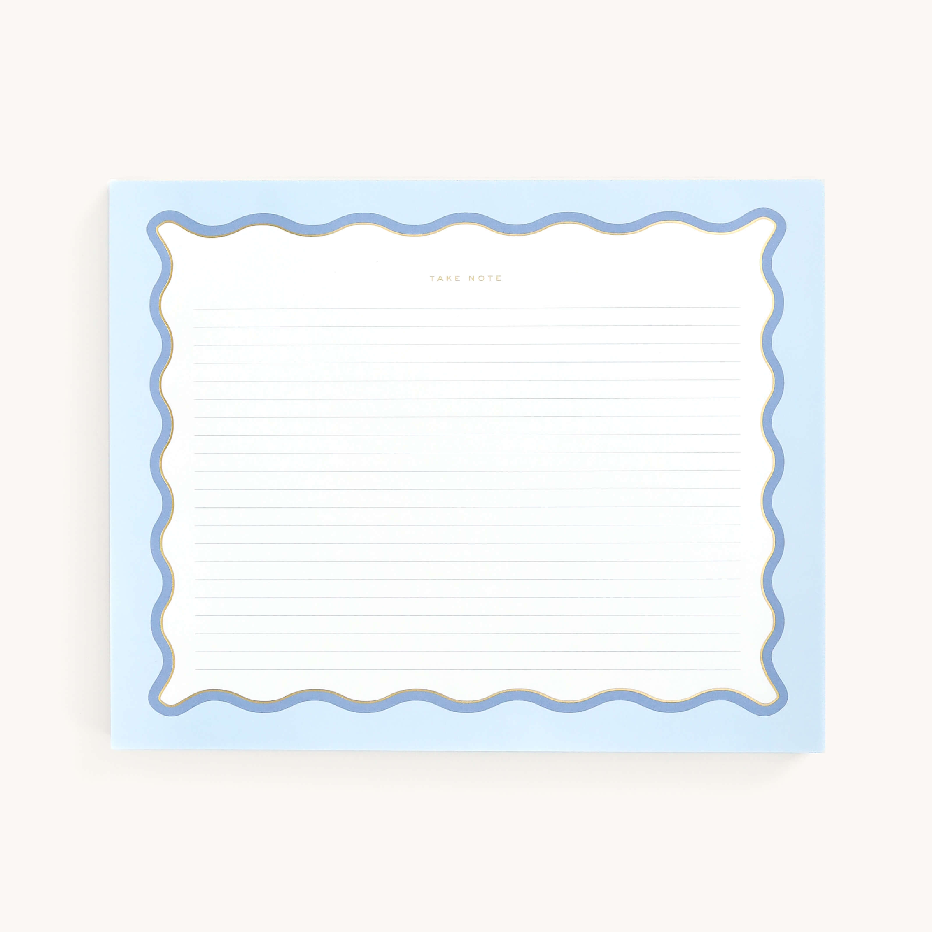 The Simplified Notepad - Scallop Lined features a blue scalloped border and gold foil accents. It has horizontal blue lines with Take Note at the top, measures 8 x 10, and rests on a light beige background.