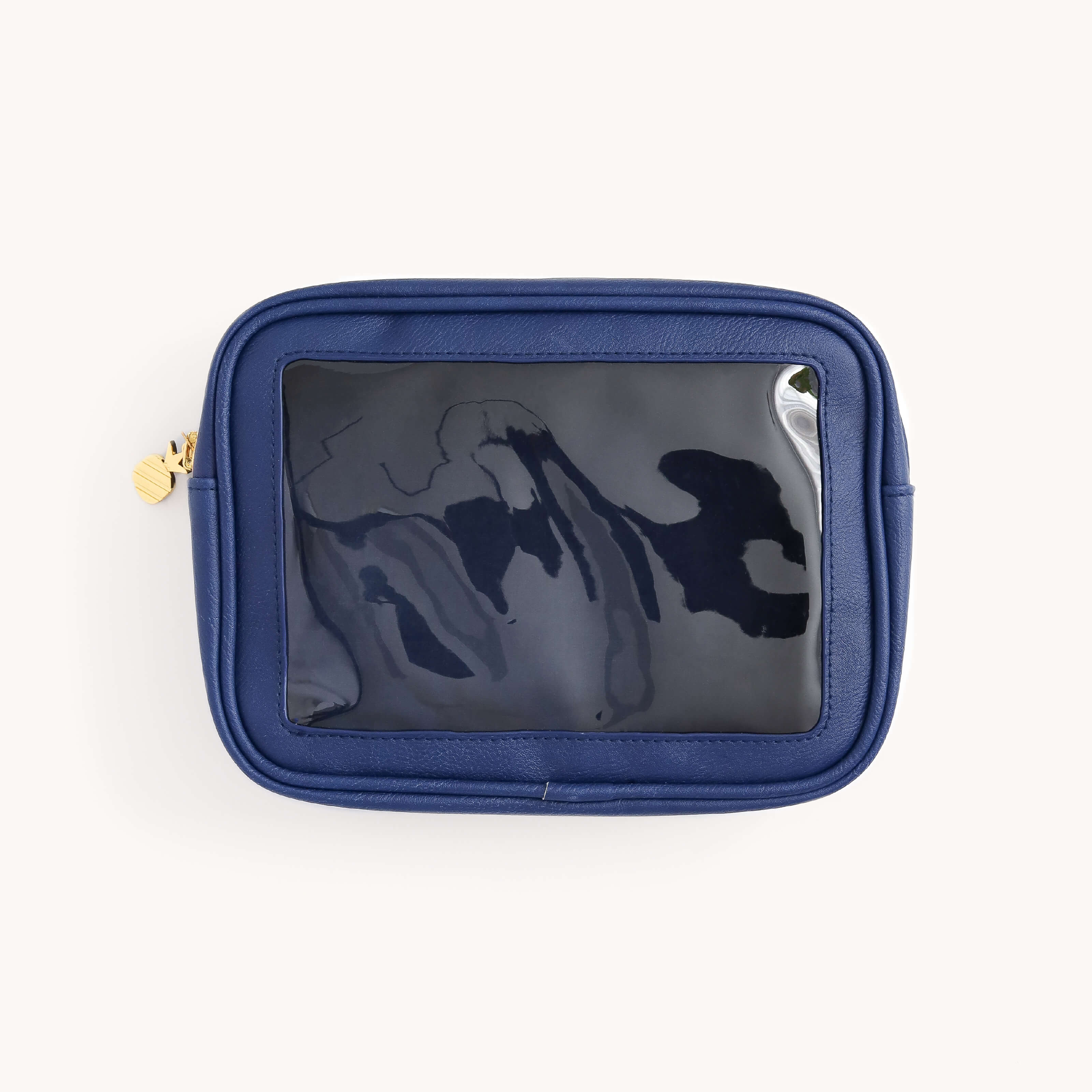 The Simplified Leatherette Travel Bag in navy features a transparent plastic window and a gold zipper pull, perfect for organizing loose items. Its stylish design sits well against a plain white background, offering both elegance and TSA-friendly convenience.