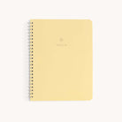 The Simplified Workbook - Meal Planning, a yellow spiral-bound notebook with MEALS in silver on its cover, is perfect for organizing your meals. Placed against a white background, its set to be your essential meal planner companion.