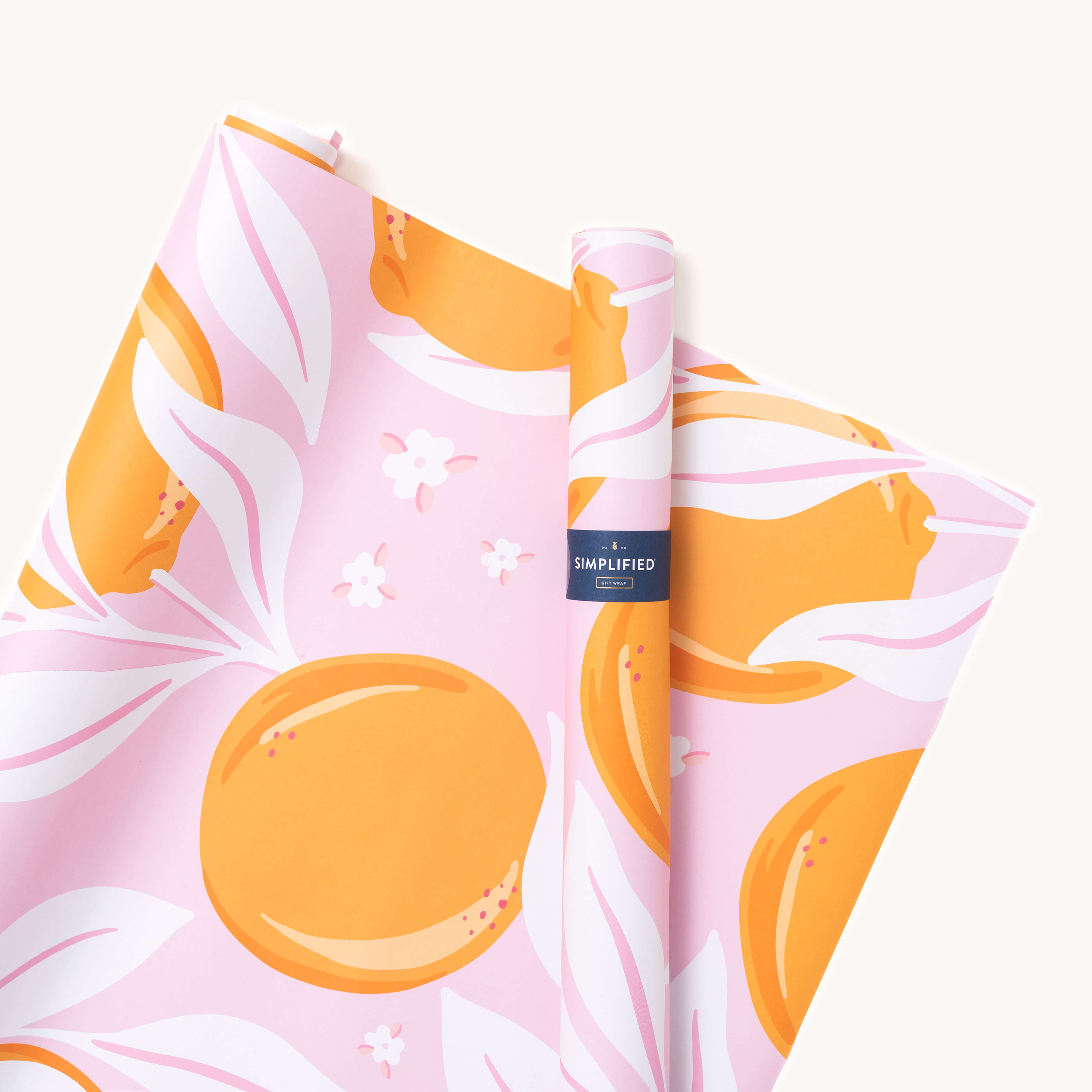 Simplifieds Wrapping Sheets - Blush Oranges add a vibrant, joyful touch with hand-painted orange fruits and white leaves on a pink background. A small blue label with text is visible on one partially unrolled roll.