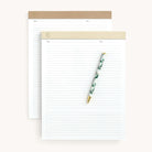 The Legal Pad Set - Ivory & Fawn Dapperdesk by Simplified includes two premium notepads featuring brown and beige headers, lined pages with checkboxes, and elegant gold foil lettering. A decorative pen with a green leaf pattern adds sophistication to the set.