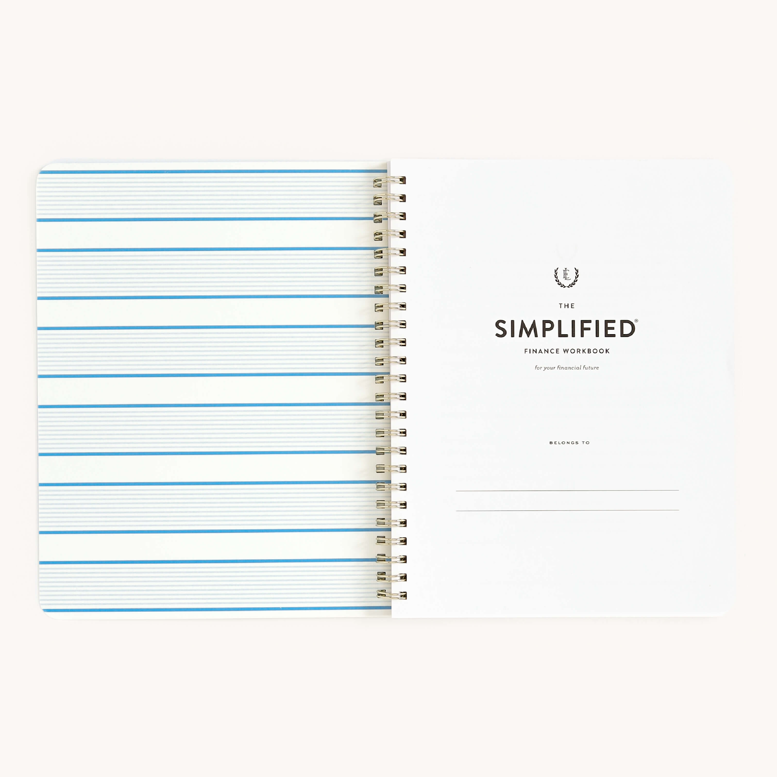 A spiral-bound notebook with left pages featuring blue lines and a right page titled Workbook - Finances by Simplified. This money management tool includes a Belongs to section at the bottom to help you achieve your financial goals.