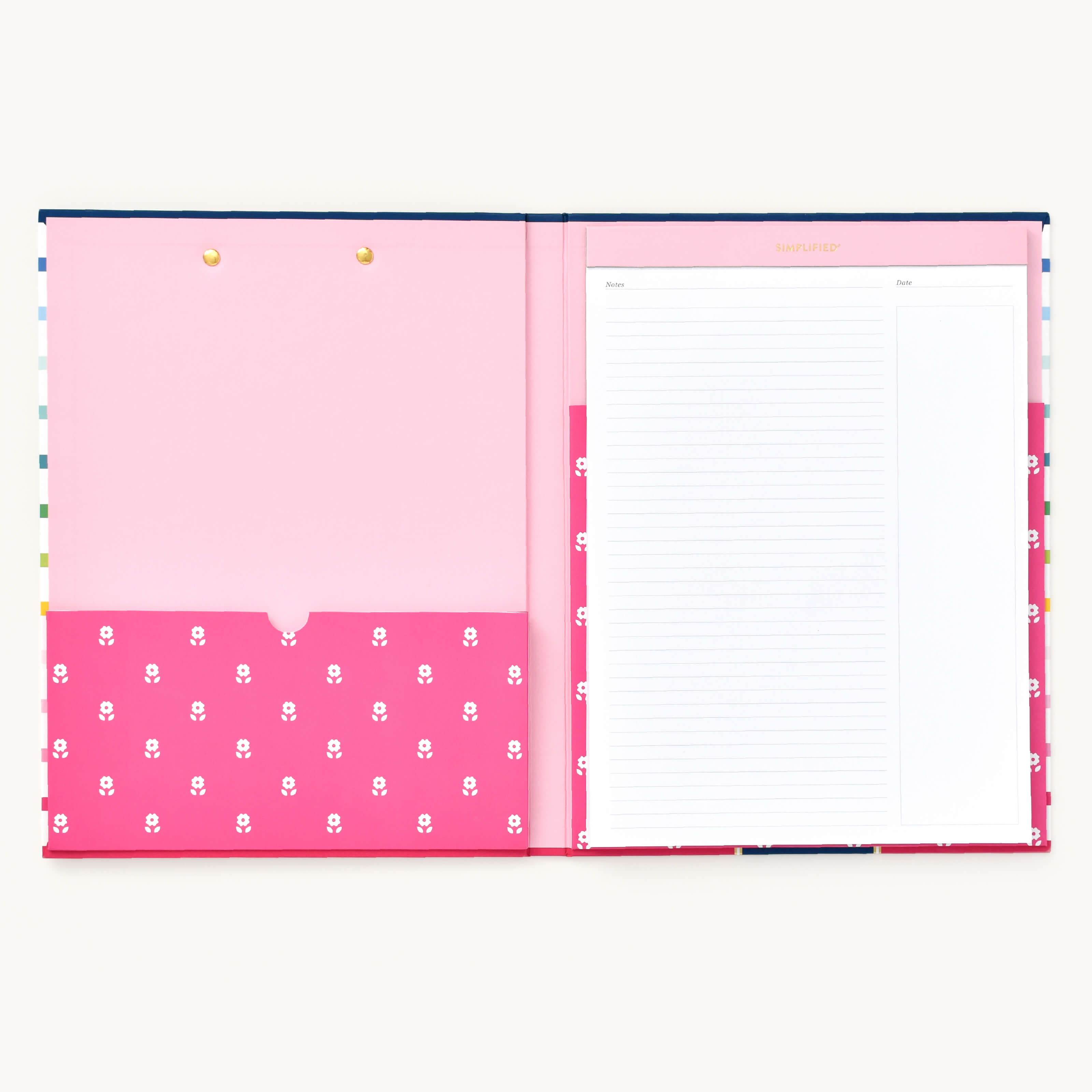 The Clipfolio - Happy Stripe by Simplified features an open notebook with a pink interior. The left pocket has white floral patterns and two top gold fasteners for organizing essentials, while lined paper on the right shows a Simplified header. Its light grey background complements the cheerful striped cover.