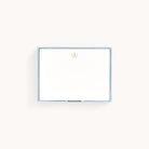 The Desk Jotter - Carolina Linen by Simplified is a closed rectangular box in light blue with a gold embossed emblem on top, set against a plain white background.