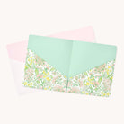 Two open file folders from the Simplified Pocket Folder Set on a white background: one in mint green with floral patterns of pink flowers and green leaves, the other in pale pink with vertical lines. Ideal for organizing papers, these stylish folders enhance document storage solutions.