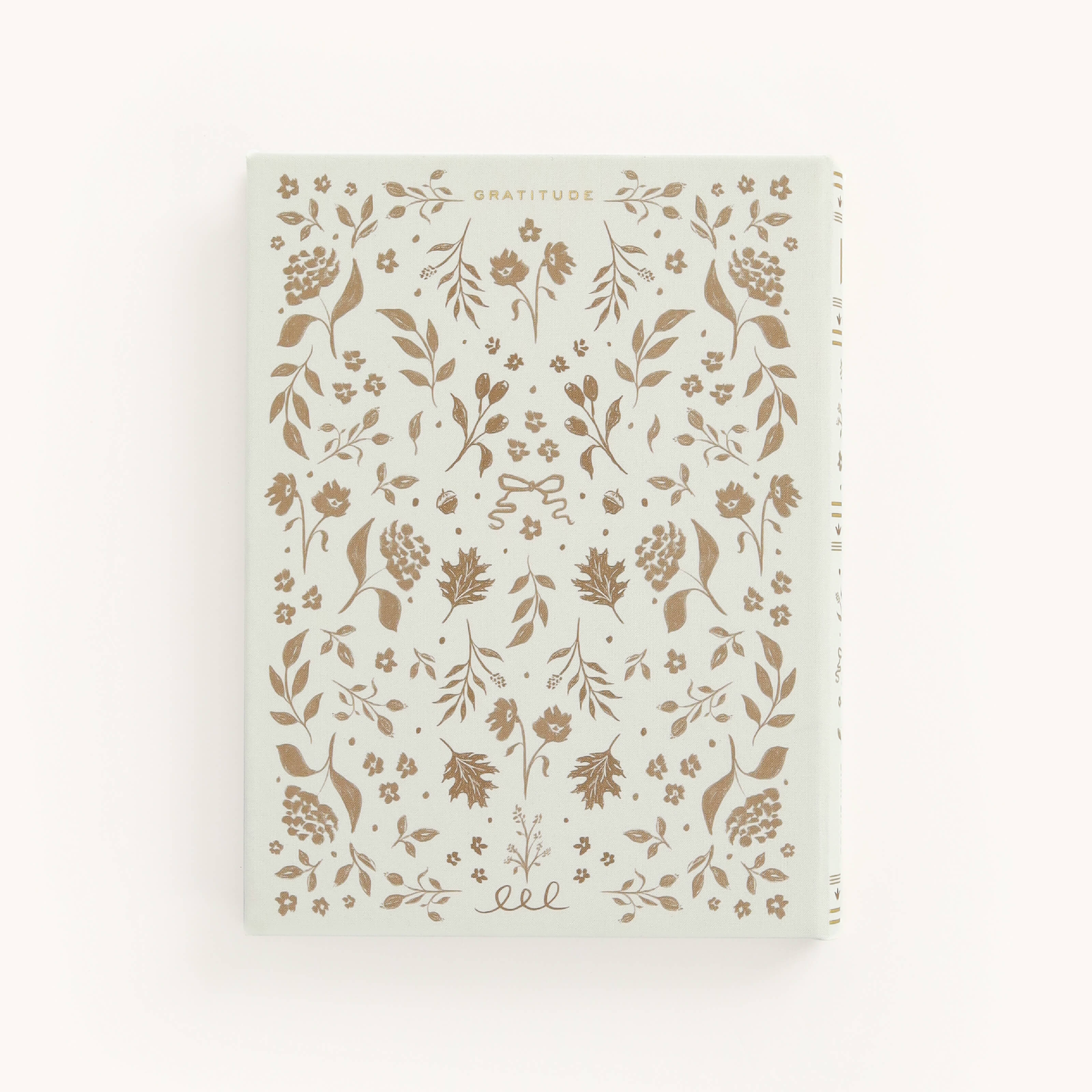 The Simplified Linen Journal - Gratitude features a linen cover with a gold hand-painted floral design on a pale background, embossed with Gratitude and surrounded by elegant leaves and flowers.