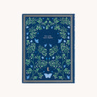 The Simplified Linen Journal - Navy features a creativity-inspiring design with intricate green vine and leaf patterns, delicate blue butterflies, and the phrase less rush, more rhythm elegantly embossed in silver, complemented by a small reflective monogram E. at the bottom.