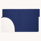 The Leatherette File Folder - Ivory by Simplified offers a minimalist design with durable materials, featuring a semicircular white pocket on the left for document organization. The open blue portfolio case sits against a plain white backdrop, perfect for stylish office use.