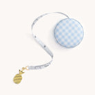 A Simplified brand measuring tape with a blue and white checkered casing and a gold pineapple charm at the end of the soft fabric tape is extended against a plain white background, ideal for quick measurements.