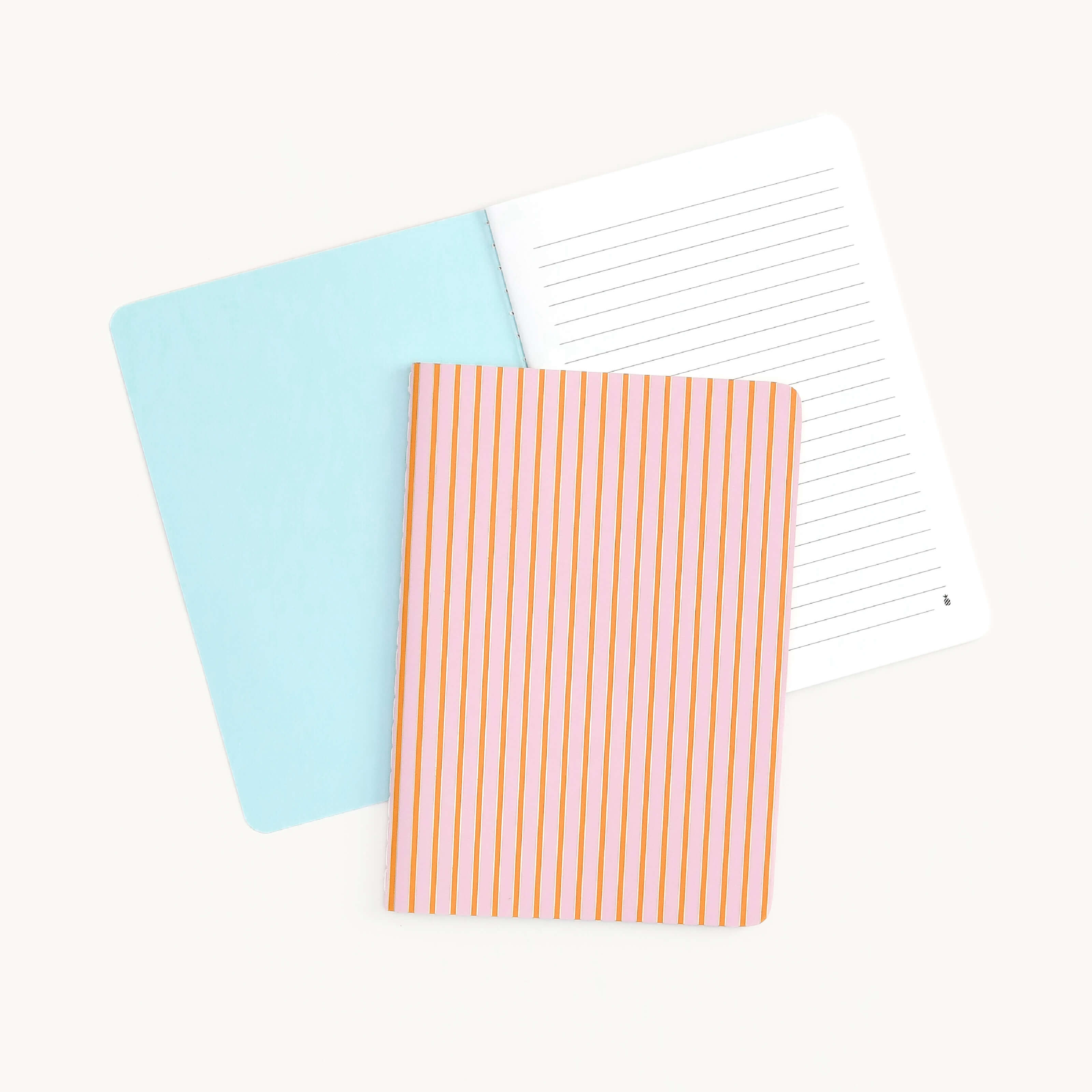 Two Simplified mini notebooks are shown: one open with a light blue cover and blank lined pages, and another closed featuring the Cabana Pinstripe design with custom orange and white stripes, set against a plain white background.