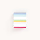 The Patterned Pen Cup - Happy Stripe by Simplified is square-shaped with a light background and horizontal, equally spaced colorful stripes in shades of blue, green, yellow, pink, and red.