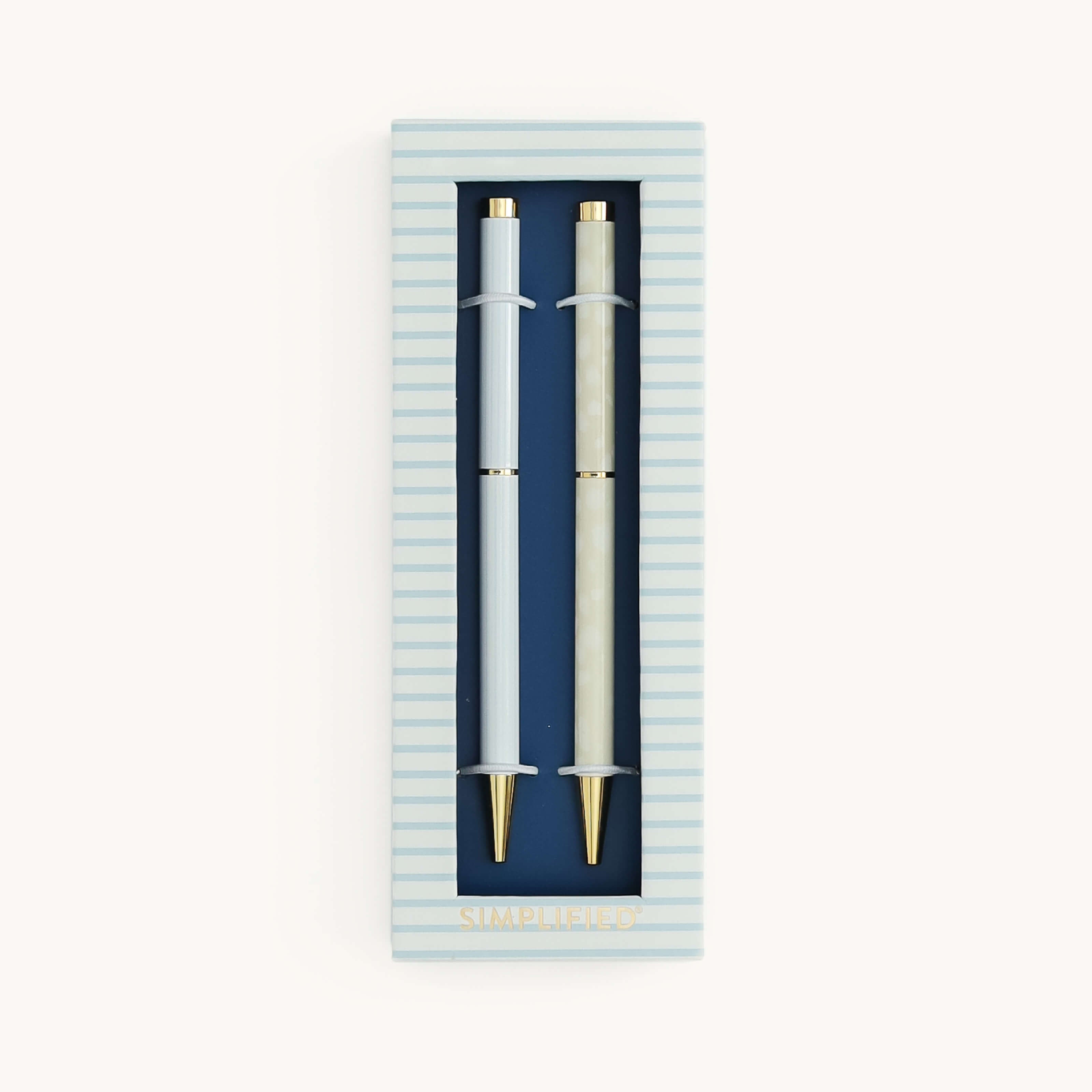 Simplified by Emily Ley | Twist Pen Set featuring two metal pens in Coastal Stripe and Ivory Antelope designs, shown in a Coastal Stripe two-piece box with a clear view window.