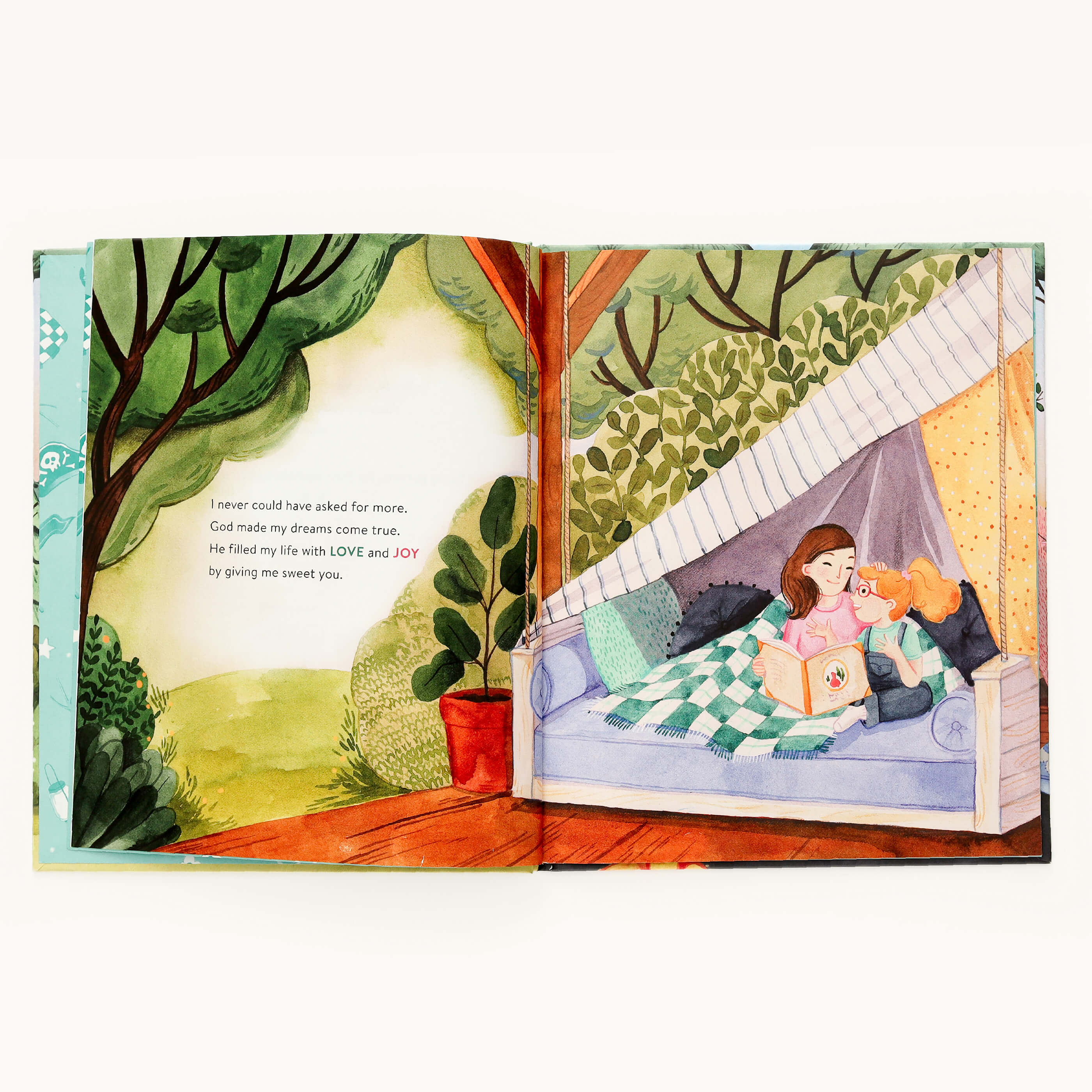 An open picture book, Youre Always Enough by Emily Ley, from Simplified, shows a woman reading to a child under a cozy blanket amidst greenery. A heartfelt message on individuality and self-esteem graces the left page.