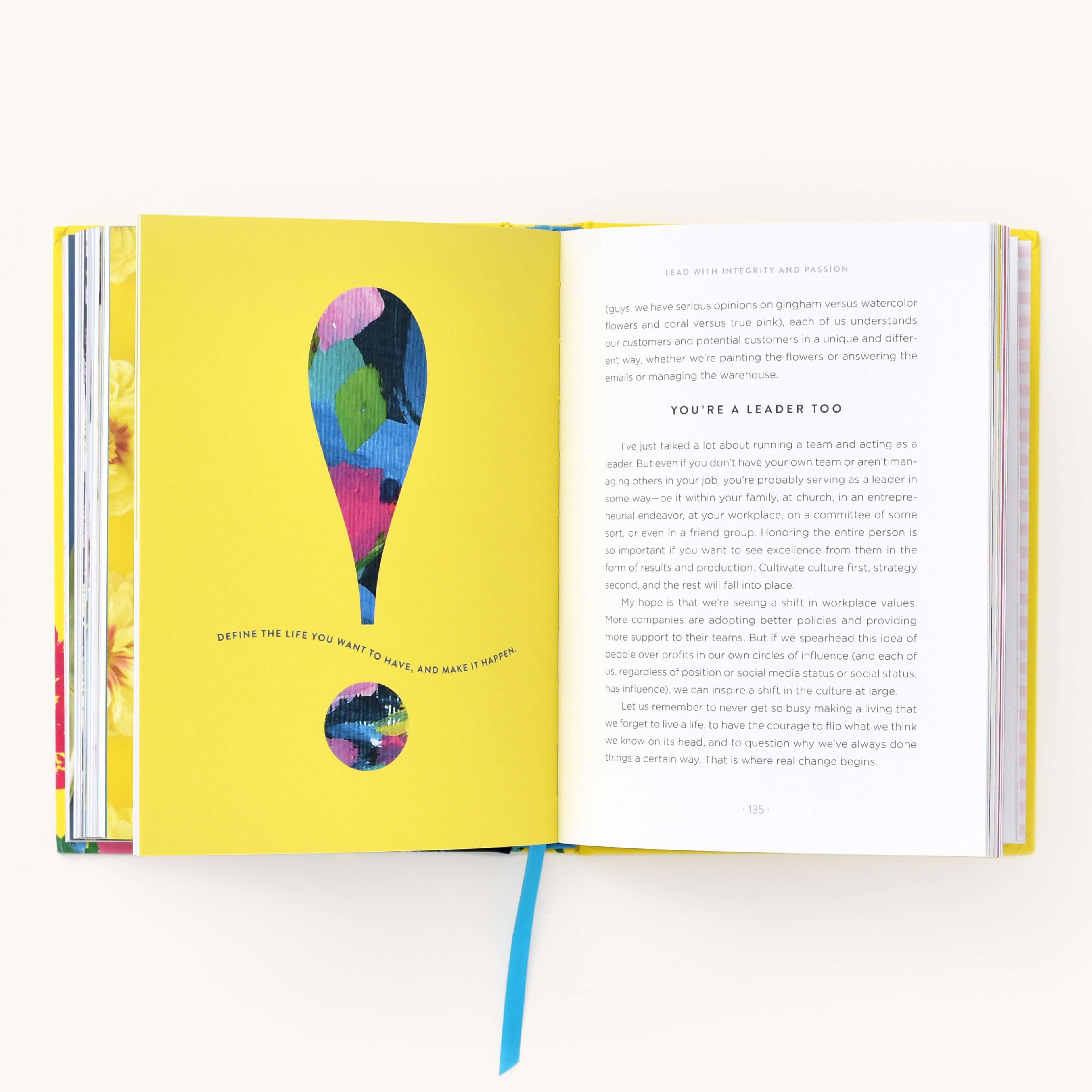 The open book Growing Boldly by Emily Ley from Simplified features a colorful exclamation mark with the message DEFINE THE LIFE YOU WANT TO HAVE, AND MAKE IT HAPPEN. On the right, it reads YOURE A LEADER TOO, highlighting courage and resilience. The book is complete with a blue ribbon bookmark.