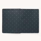 Two rectangular 2024-2025 Weekly Dapperdesk Planners by Simplified, featuring a black leatherette cover with golden bee patterns, sit side by side on a light background. The planner on the right is slightly raised compared to the one on the left.