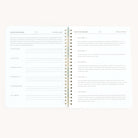 The Workbook - Wellness by Simplified is a minimalist spiral-bound notebook featuring two pages with text and lines. It includes prompts for personal reflection, a checklist of challenges, and goal-tracking spaces, fostering focus and self-care with its clean layout.