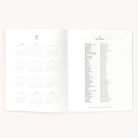 2025 Calendar Year Planner by Emily Ley in Happy Stripe cover open to the yearly calendar overview and holidays list. Features a two-page spread with a full 12-month calendar view on the left and important U.S. holidays on the right. 