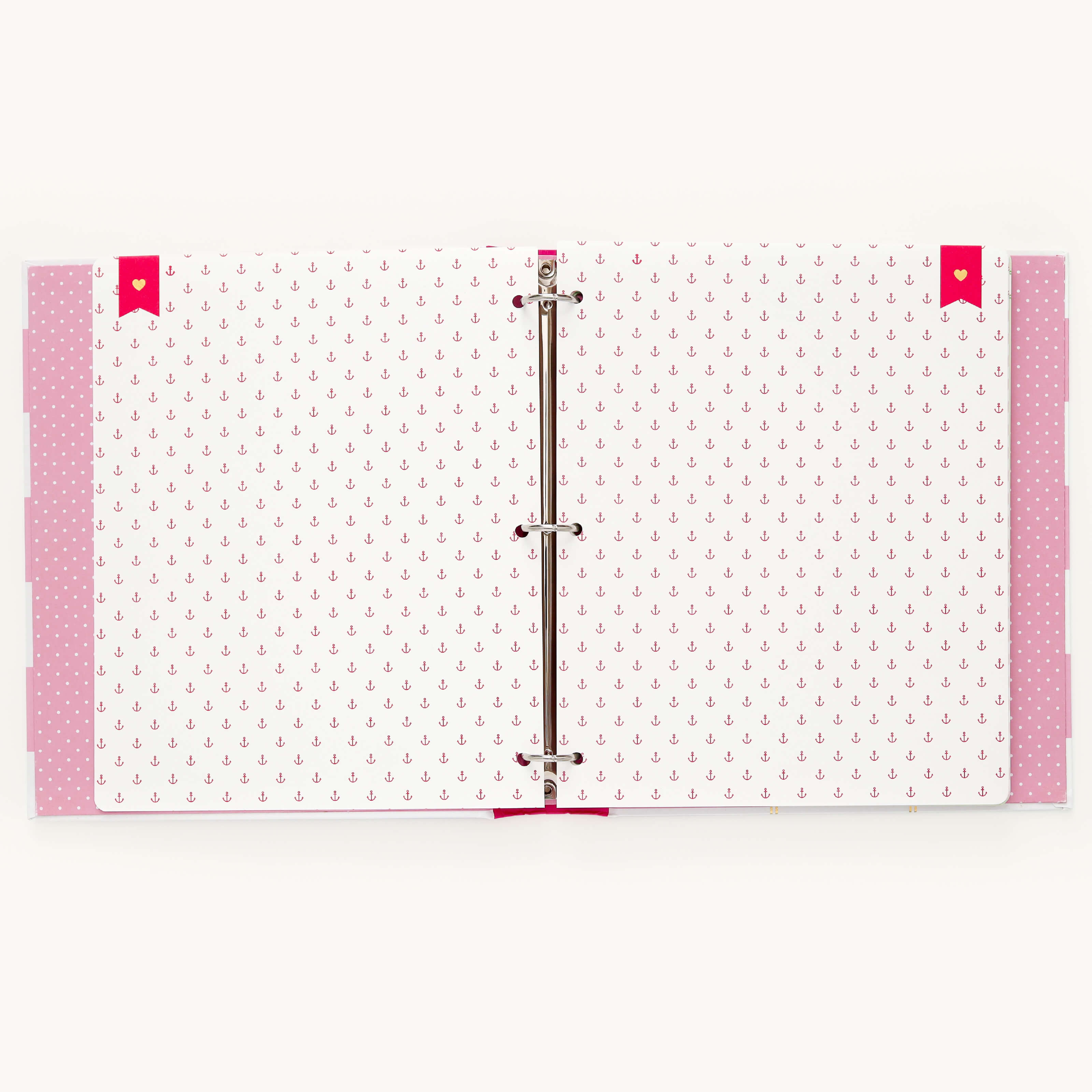 An open binder adorned with pink and white paper and a small red anchor pattern, similar to the Simplified Big Kid Book - Raspberry. Pink tabs peek from the edges, and red bookmarks highlight adventures. The binder rings are partly visible in the center.