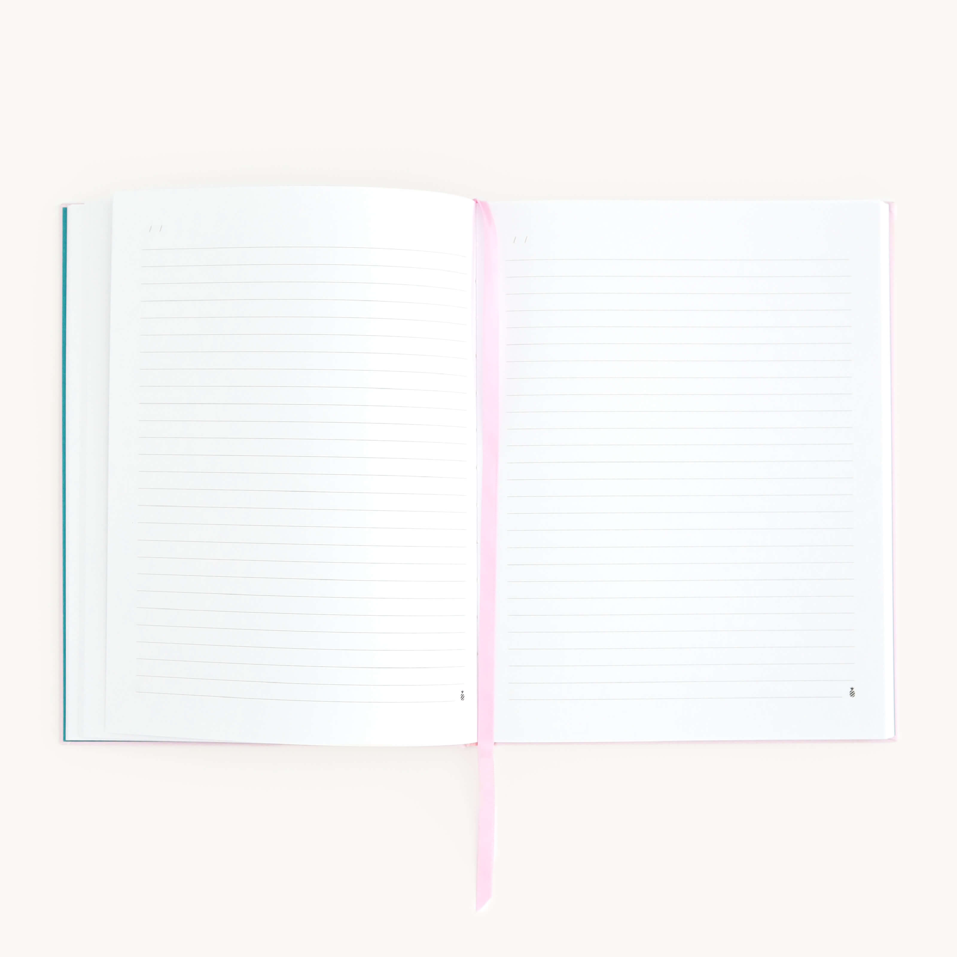 The open Linen Journal - Blush by Simplified, with lined pages and a pink ribbon bookmark, lies flat on a light surface, inviting creativity. Its off-white pages invite reflection, while the partially visible cover hints at countless unwritten entries.