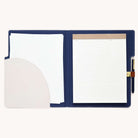 The Simplified Leatherette File Folder in Ivory is durable and stylish. It includes a notepad with lined pages on the right side, a pen clip, and on the left, features a pocket holding blank sheets for optimal office organization.