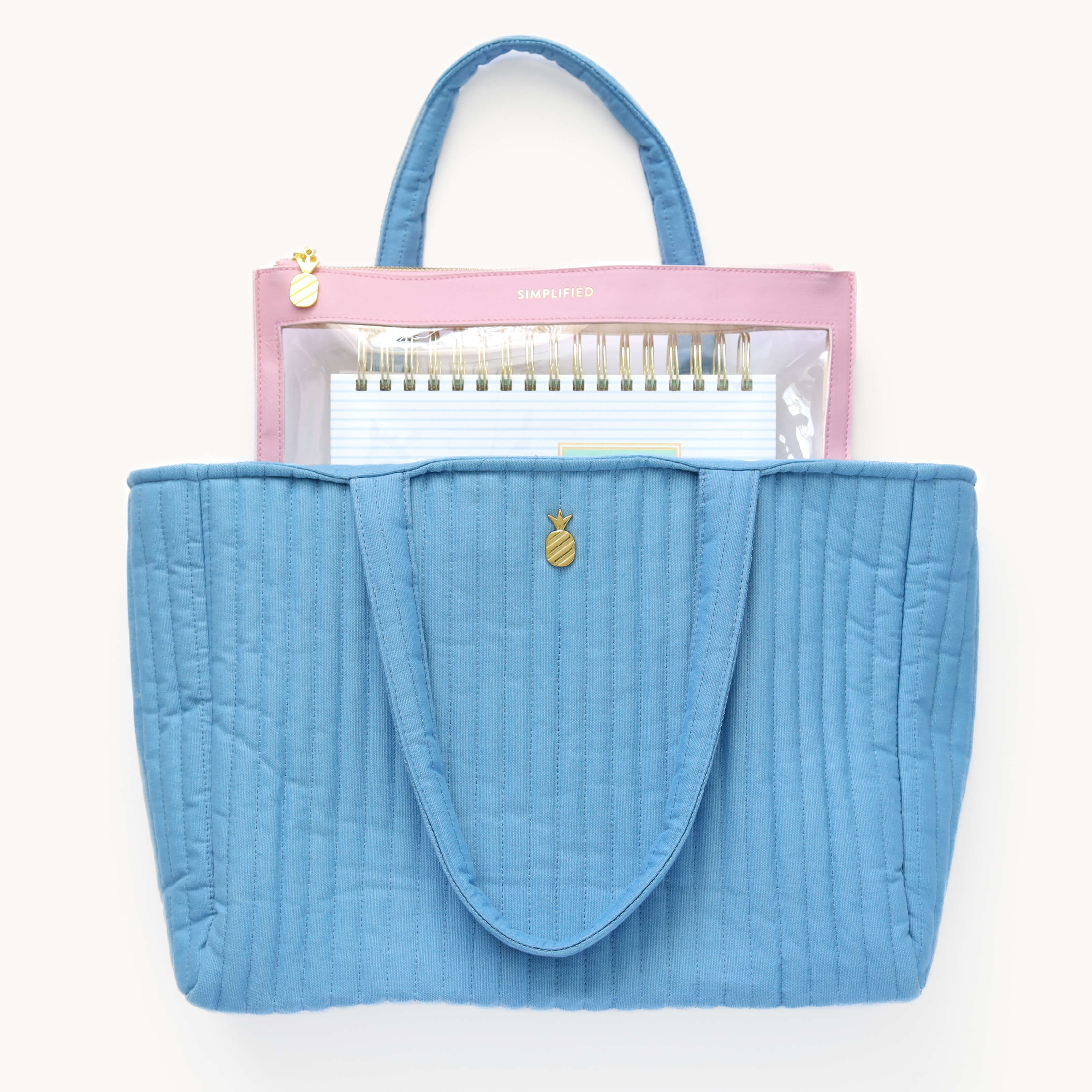 Simplified Planner inside a blush Leatherette Pouch, peeking out from the Quilted Tote Bag in French Blue.