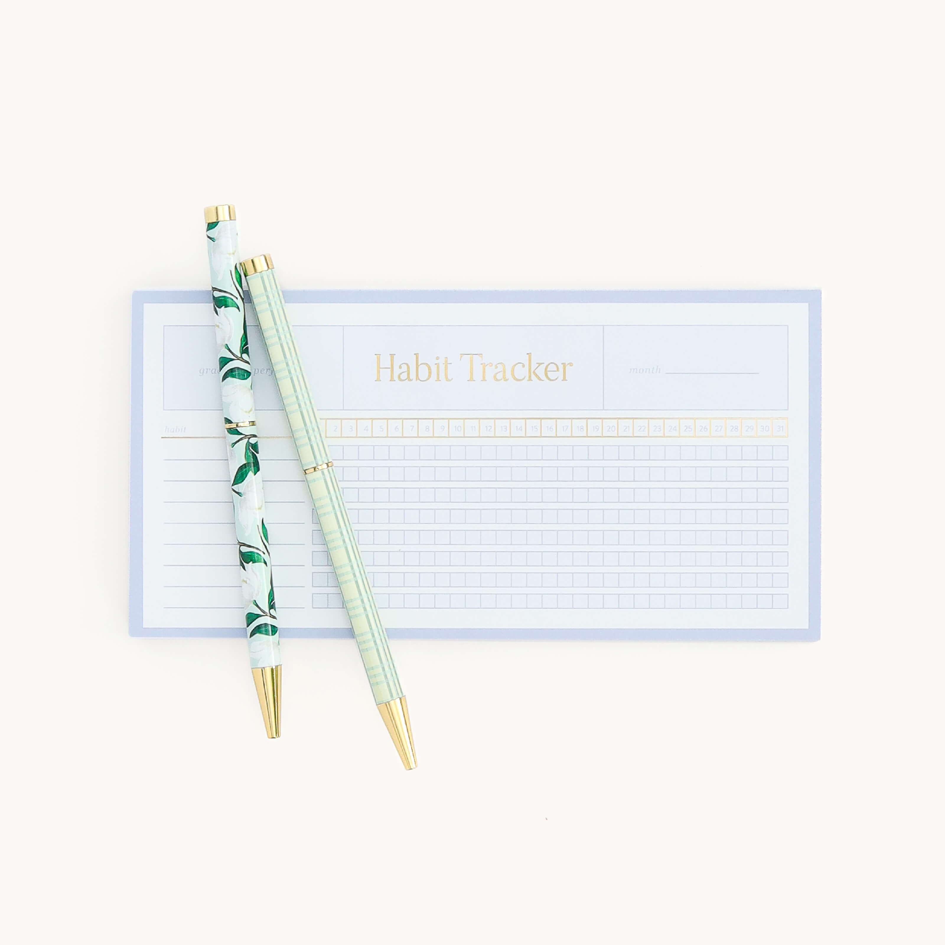 Simplified by Emily Ley | Twist Pen Set featuring two metal pens in Savannah Blooms and Pistachio Plaid designs used alongside the Habit Tracker notepad.