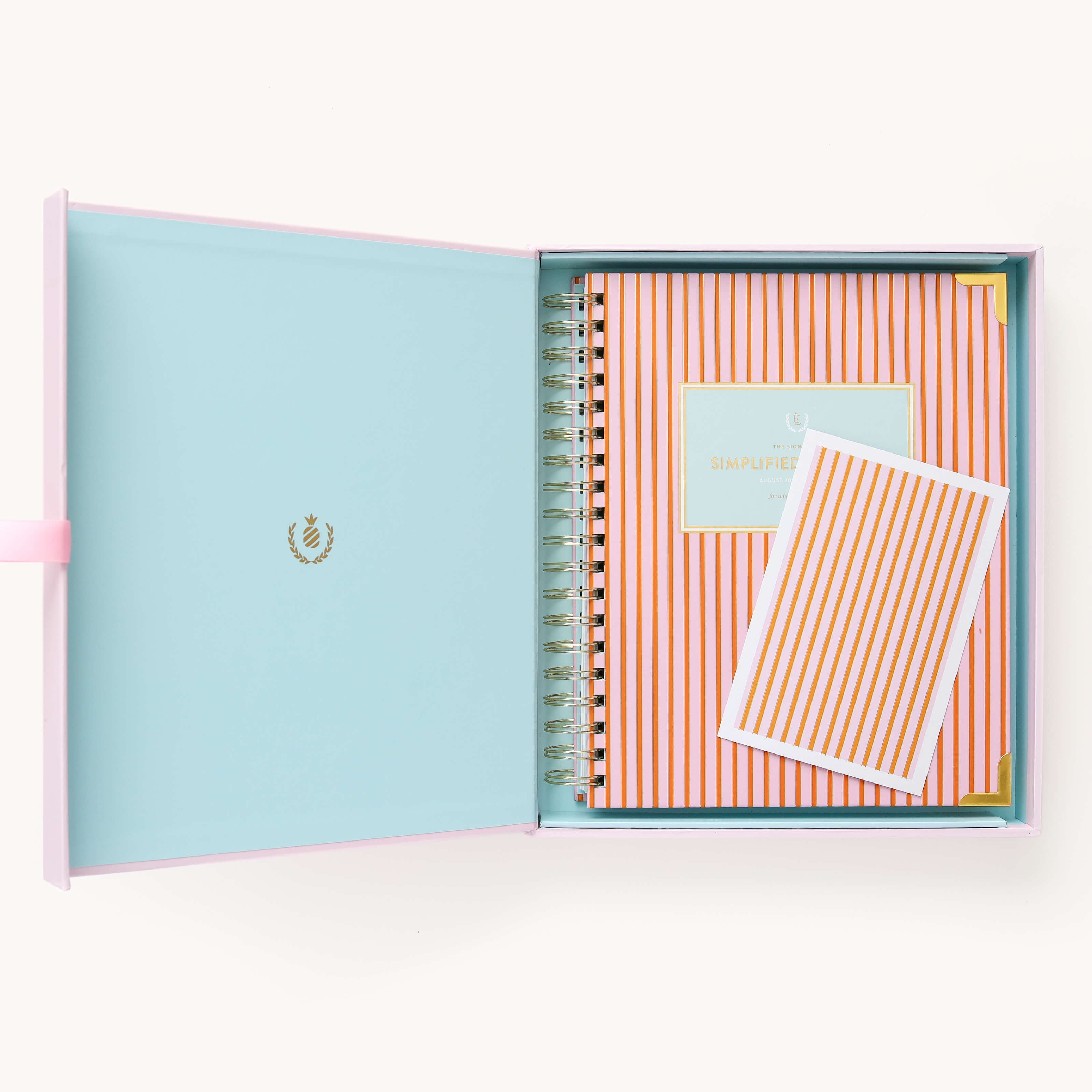 2025 Calendar Year Weekly Simplified Planner by Emily Ley in the Cabana Pinstripe cover design, placed inside a blush pink keepsake box with gold foil detailing. Includes a matching art print for added inspiration. Perfect for organization, time management, and productivity. 