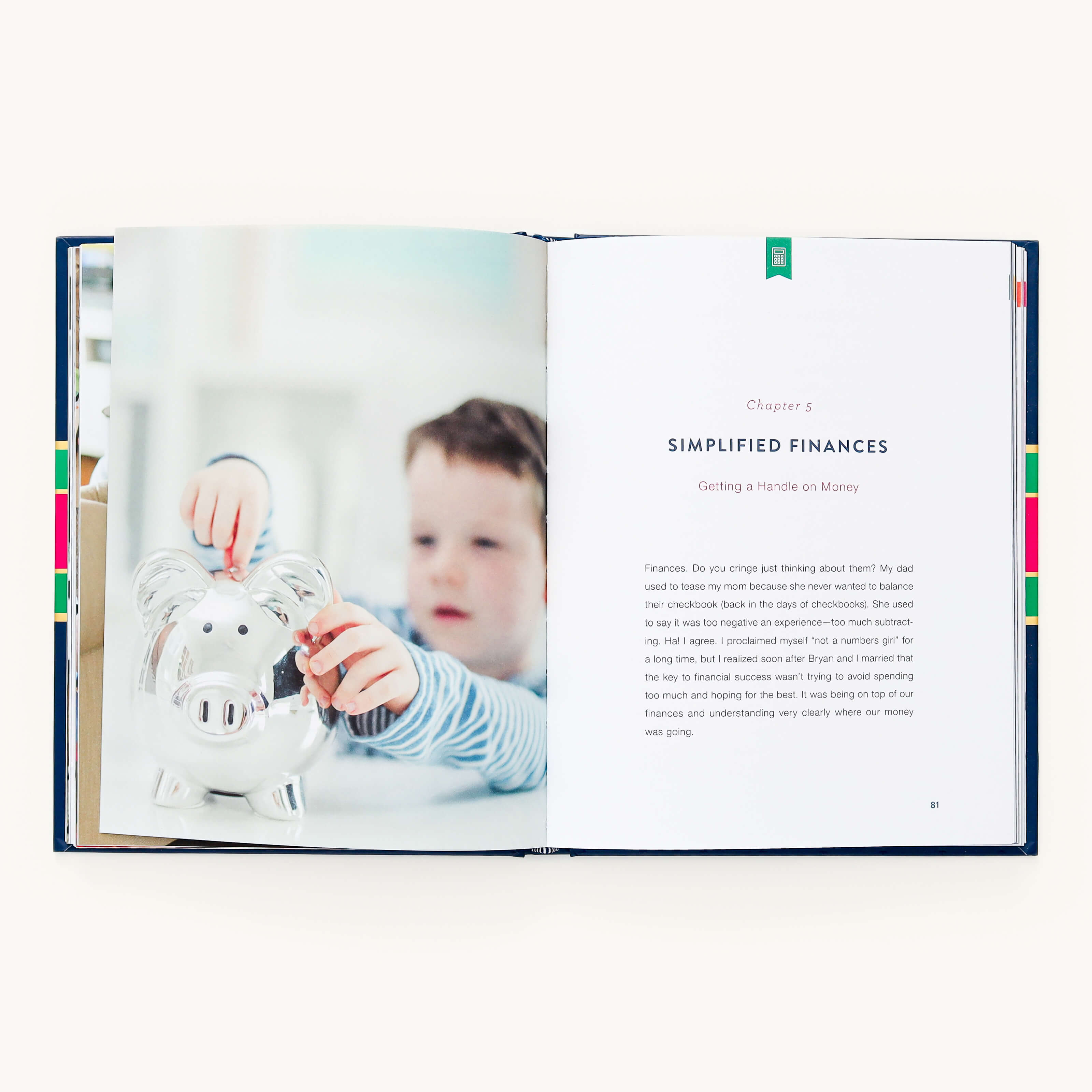 An open book from A Simplified Life by Emily Ley displays a young boy putting a coin into a piggy bank beside Chapter 5, Simplified Finances: Getting a Handle on Money, featuring practical tips for intentional living, with text starting below the chapter title.