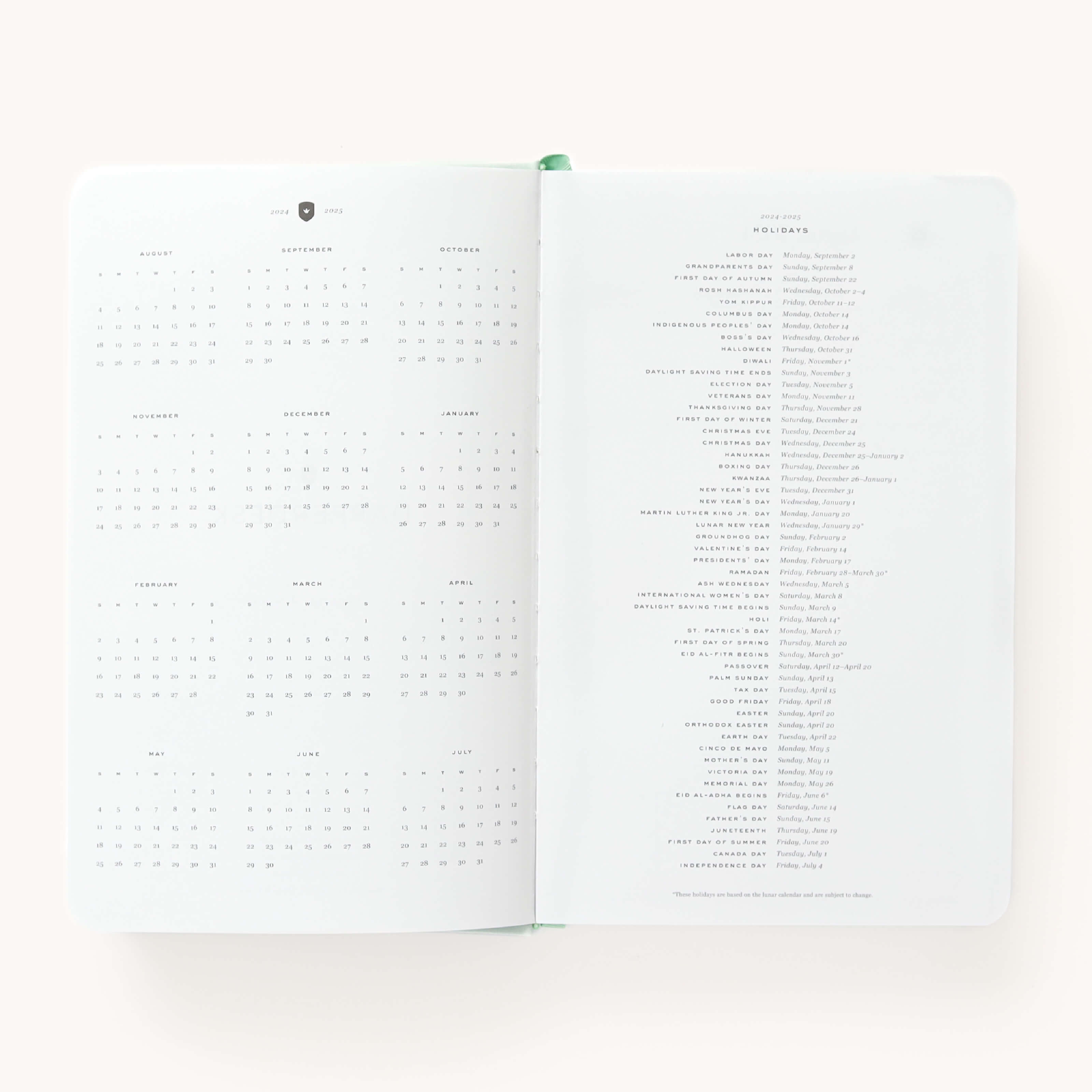 2024-2025 Daily Dapperdesk Planner by Emily Ley in the Sea Salt leatherette cover open to the yearly calendar overview and holidays list. Features a two-page spread with a full 12-month calendar view on the left and important U.S. holidays on the right. 