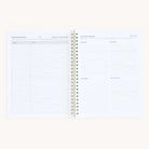 The Simplified Workbook - Hosting is a spiral-bound planner. On the left page, find lined sections for Name and Address, while the right page features quadrants: Holidays, Seasonal, Birthdays, and Just Because to organize memorable gatherings effortlessly.