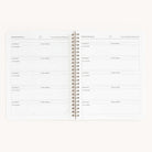 The open Workbook - Meal Planning by Simplified shows a meal planner layout. Each spiral-bound page, titled Favorite Takeout & Restaurants, includes sections for restaurants and phone numbers. The pages are plain with light grey text, perfect for organizing meal planning.