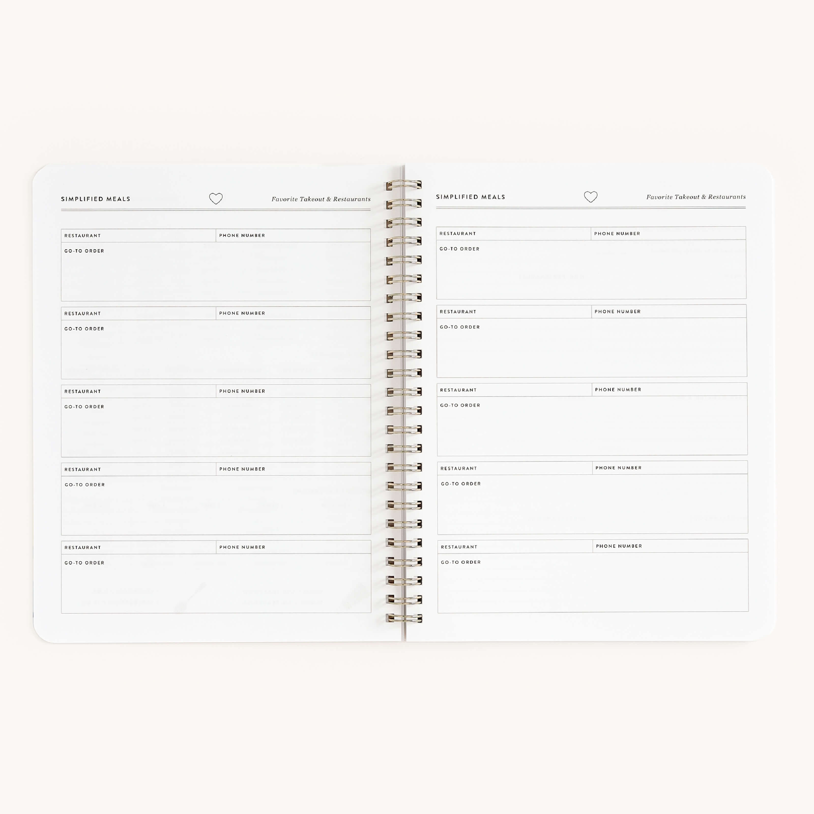 The open Workbook - Meal Planning by Simplified shows a meal planner layout. Each spiral-bound page, titled Favorite Takeout & Restaurants, includes sections for restaurants and phone numbers. The pages are plain with light grey text, perfect for organizing meal planning.