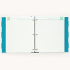 The Simplified Big Kid Book - Teal is an open binder with a three-ring mechanism featuring blank lined pages with polka dot borders, ideal for documenting child growth. It has decorative tabs labeled Proud Moments and Best Words in light blue and teal.