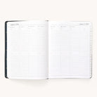 The Simplified 2024-2025 Weekly Dapperdesk Planner - Black Tie features a weekly layout from August 5 to August 11, 2024. It has high-quality paper with daily columns, lined sections for notes and activities, a black leatherette cover with round metal rings, and visible tabs on the right.