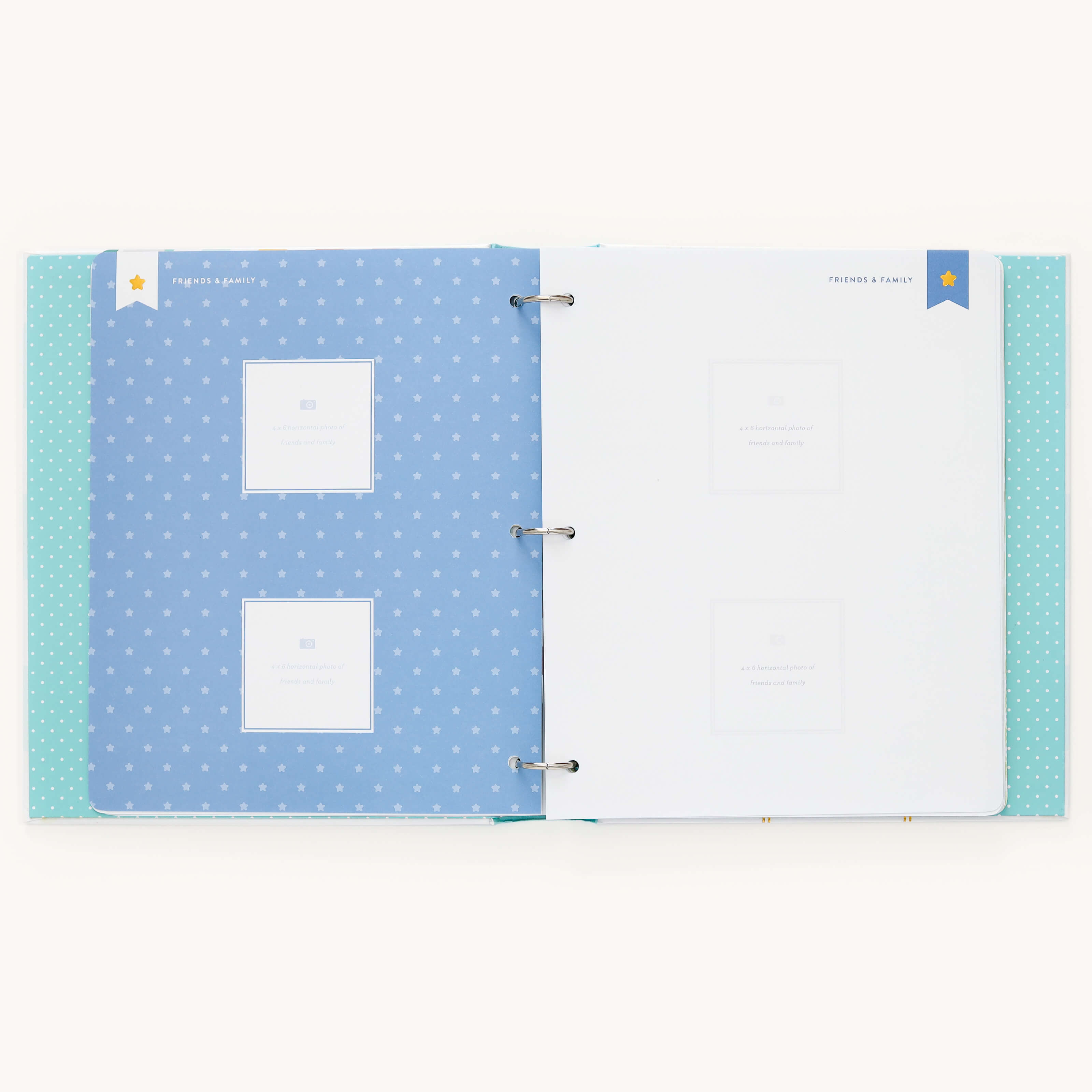 The Baby Book - Mint by Simplified features a customizable blue left page with star patterns and Babys Debut frames, while the white right page provides writing space with a bookmark icon for personal notes. Add personalized moments with customizable page packs.