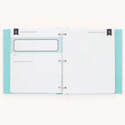 Open the Simplified Baby Book - Mint, featuring a teal cover with a dotted interior. The left page includes a Details section with label and writing space, while the right page is blank except for a top label. Secured by metal rings, its ideal for customizable pages or baby keepsakes.