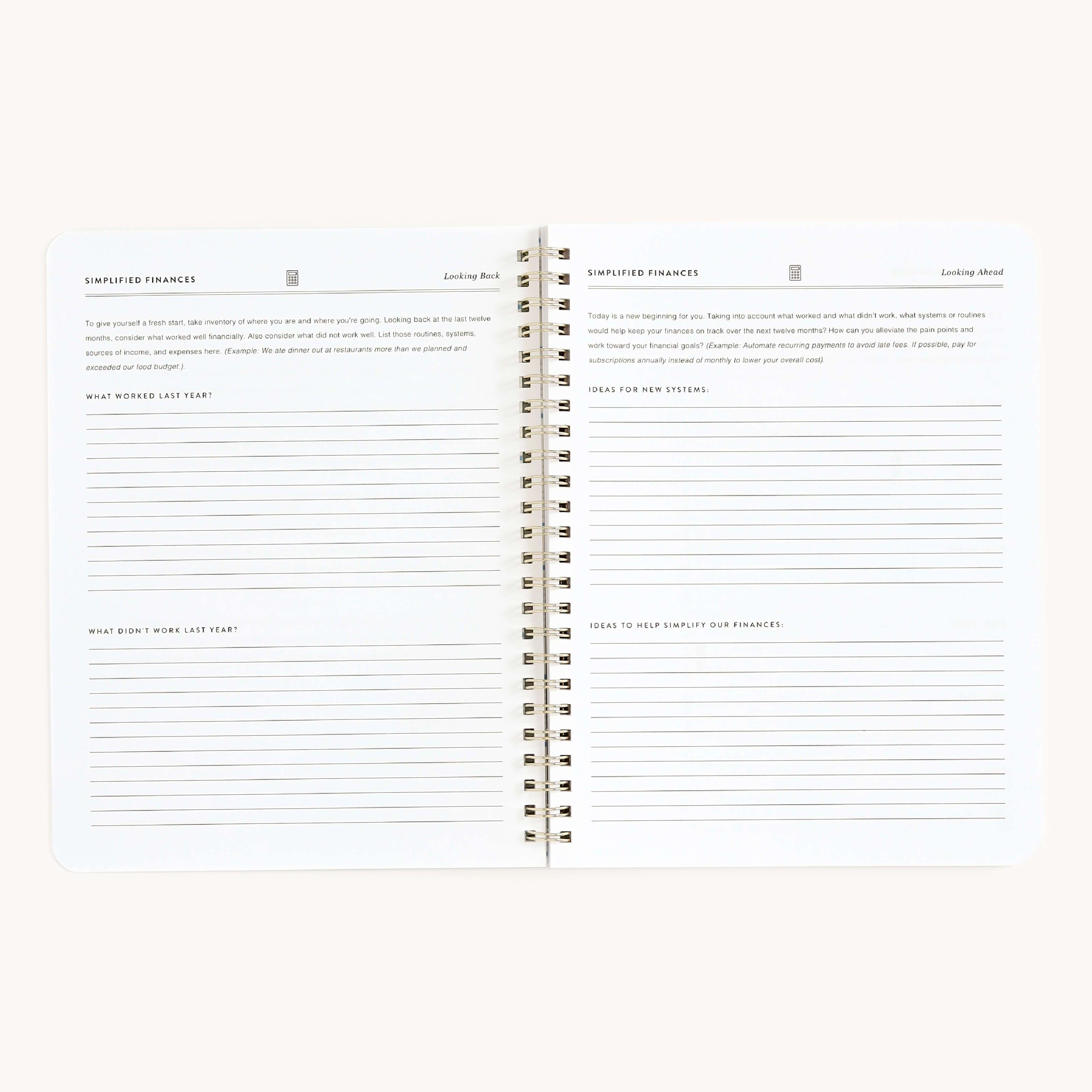 The Workbook - Finances by Simplified is an open spiral-bound notebook with lined pages, featuring sections like LOOKING BACK and LOOKING AHEAD, with prompts such as WHAT WORKED LAST YEAR, WHAT DIDNT WORK, and GOALS FOR NEW YEAR. Its ideal for managing money and tracking financial goals.