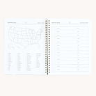 The Simplified Workbook - Travel Planning is an open spiral-bound planner with a US map and state checklists on the left page, while the right page has blank lines labeled Date for your travel itineraries.